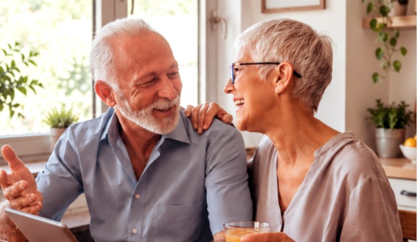 Older couple laughing together at home